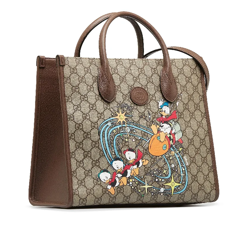 Women Gucci bags with a snap - button closure and a decorative charmGucci x Disney GG Supreme Donald Duck Tote (SHG-mJ8LfU)